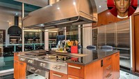 Pernah mengira-ngira seperti apa dapur rapper ternama? Dapur ini milik Pharrell Williams di Miami dengan peralatan bernuansa kayu dan stainless steel. Keren ya? Foto: Istimewa