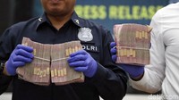 Polisi menunjukkan uang tunai yang turut menjadi barang bukti kasus tersebut. Akibat penipuan tersebut kerugian ditaksir mencapai Rp 113 miliar.