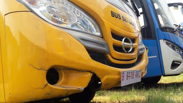 Bus sekolah terlihat rusak di bagian bumper.