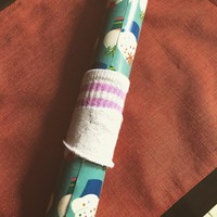 Dari pada tidak terpakai, gunakan kaus kaki bayi yang sudah usang untuk menggulung kertas kado atau sampul buku. Foto: Instagram