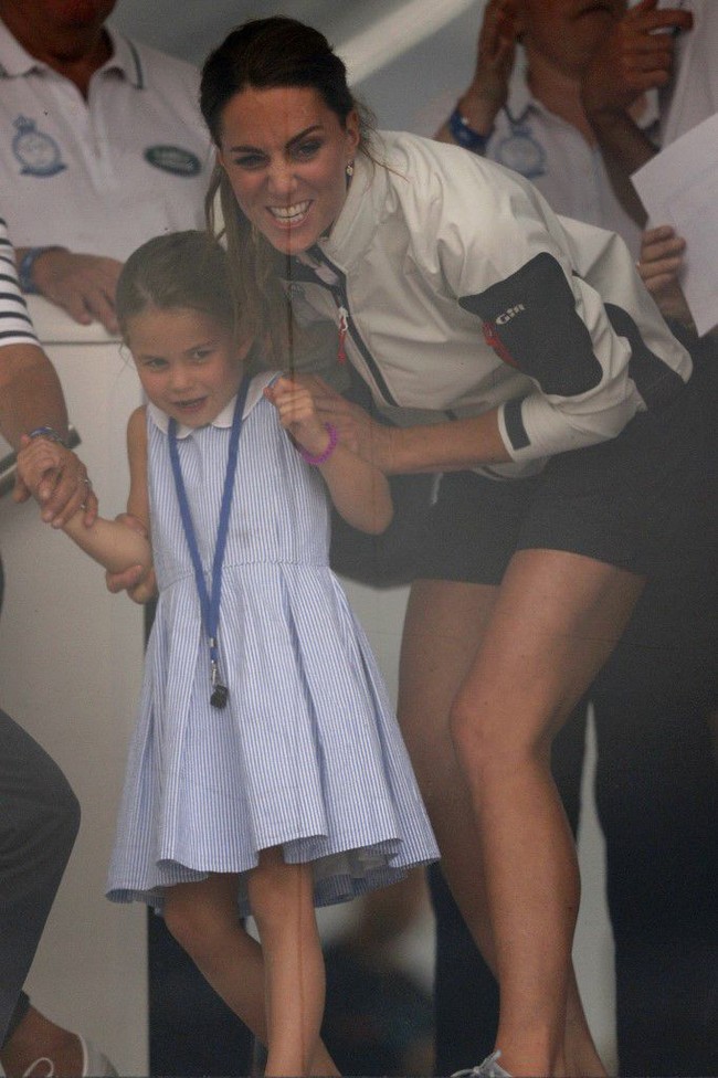 Kaget dengan kelakuan putrinya yang baru berusia empat tahun itu, Kate Middleton pun langsung merangkul Charlotte sambil tertawa. (Foto: Adrian DENNIS / AFP)