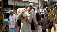 Seorang warga terlihat membawa seekor kambing. REUTERS/Mohamed al-Sayaghi.