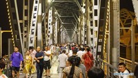 Orang-orang terlihat di atas jembatan rel Sungai Songhuajiang yang telah direnovasi di Harbin, ibu kota Provinsi Heilongjiang, China timur laut. Foto: Dok. Xie Jianfei/Xinhua
