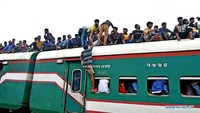 Seorang pria tampak menaiki kereta dibantu penumpang lainnya. Foto: Dok. Str/Xinhua