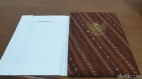 Sampul kertas putih dikeluarkan dari kardus. Setelah sampul dibuka masih ada map berlapis kain batik. Naskah asli Proklamasi melalui proses pemeliharaan seperti enkapsulasi (Ahmad Masaul Khoiri/detikcom)