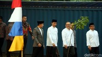 Jokowi datang mengenakan kemeja koko putih dipadankan dengan sarung. Ia langsung duduk di saf depan di lokasi.