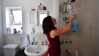 Seorang wanita warga Cape Town mengumpulkan air untuk minum dari kamar mandi. Istimewa/Straitstimes.