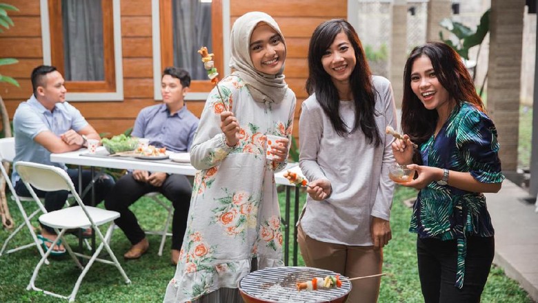 ilustrasi wanita berhijab idul adha having barbecue on the grill with a group of friends in the backyarda