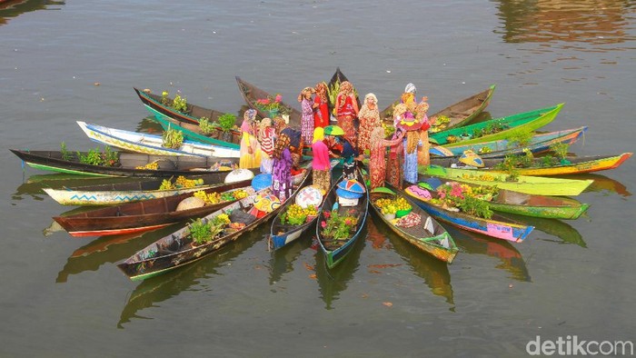 Pedagang pasar terapung melakukan atraksi jukung membentuk bunga mekar di sungai Martapura, Banjarmasin, Kalimantan Selatan, Senin (12/8/2019). Atraksi yang dibuat pedagang pasar terapung tersebut menjadi ajang promosi pariwisata Kalsel. ANTARA FOTO/Bayu Pratama S/aww.