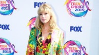 Taylor tampak kembali segar dan menawan dengan bodysuit warna-warni dari Versace. Rich Fury/Getty Images