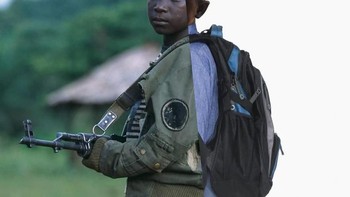 Pejuang anak dengan pose dengan pistol di fasilitas pelatihan militer selama perang saudara Liberia. Foto: Uğur Gallenkuş