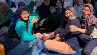 Menuruti permintaan anaknya untuk mengkurban hewan kurban di sekola anaknya, Inul Daratista pose bareng ibu-ibu saat makan bareng beralaskan terpal. Foto: Istimewa