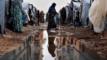 Seorang wanita berjalan melewati tenda di sebuah kamp pengungsi Suriah di kota Suruc, provinsi Sanliurfa, Turki Foto: Uğur Gallenkuş