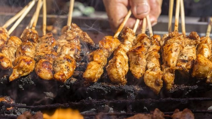 Indonesian grilled bbq meats in wooden skewers, island Bali, Ubud, Indonesia, close up