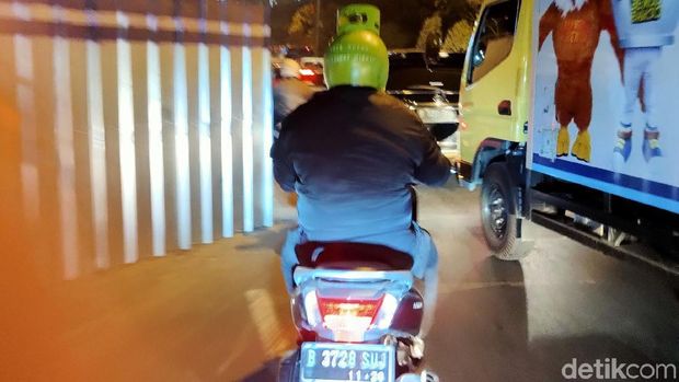 Pengendara motor mengenakan helm mirip tabung elpiji