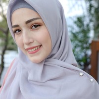 Adelia Pasha memadukan tuspin mutiara dengan hijab warna abu-abu dan inner rajut dengan tone senada. Foto: Dok. Instagram @adeliapasha