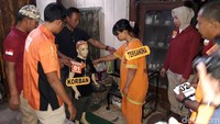 Siti Wakidah atau Ida memperagakan aksinya saat menganiaya anak kandungnya, F (6). 