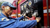 Petugas damkar diturunkan untuk membantu membersihkan trotoar.