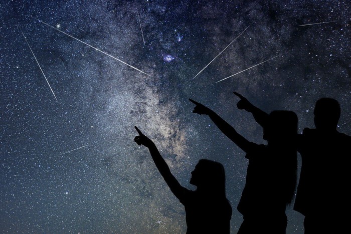 Father and his daughter are watching Meteor Shower. Night sky.