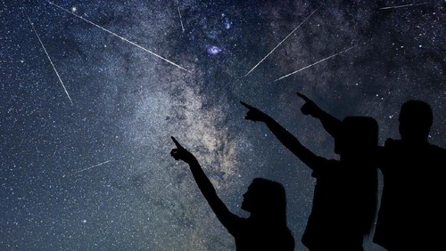 Father and his daughter are watching Meteor Shower. Night sky.