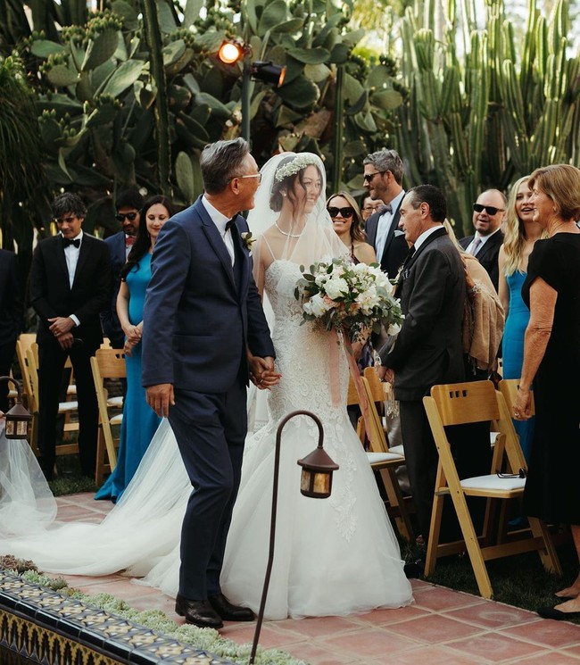 Untuk prosesi janji nikah, Michelle muncul dalam balutan gaun putih bersiluet mermaid. Tidak ketinggalan veil senada berikut headpiece yang terbuat dari rangkaian bunga. (Foto: Instagram/@themichellewie)