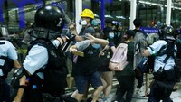 Bentrokan lagi-lagi terjadi antara polisi dengan pendemo di Hong Kong. Insiden itu bermula saat sejumlah polisi dikerahkan untuk membubarkan pendemo yang menduduki Bandara Internasional Hong Kong, pada Selasa (13/8/2019) malam waktu setempat. Thomas Peter/Reuters.