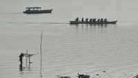 Penyedia jasa penyeberangan perahu membawa penumpang melintasi Sungai Batanghari yang diselimuti kabut asap tipis di Jambi.