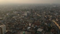 Foto udara kawasan pertokoan dan perkampungan padat penduduk yang diselimuti kabut asap tipis di Jambi, Rabu (14/8/2019).