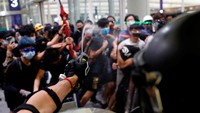 Pihak kepolisian menggunakan semprotan merica untuk membubarkan massa pendemo yang menduduki Bandara Internasional Hong Kong. Thomas Peter/Reuters.