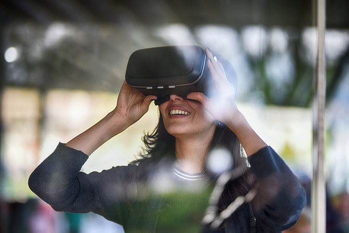 Young woman looking with VR behind the glass
