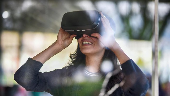 Young woman looking with VR behind the glass