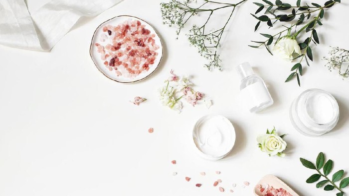Ilustrasi skincare Styled beauty corner, web banner. Skin cream, tonicum bottle, dry flowers, leaves, rose and Himalayan salt. White table background. Organic cosmetics, spa concept, empty space. Flat lay, top view