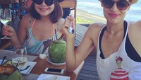 Ini pose Viola kala sedang berlibur di pantai sambil menikmati buah kelapa bersama temannya.  Foto: Instagram @lolagin