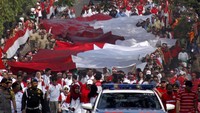 Begini penampakan kirab bendera Merah Putih raksasa berukuran 100 x 5 meter yang diarak di Jalan Raya Tegar Beriman, Cibinong, Bogor, Kamis (15/8/2019).