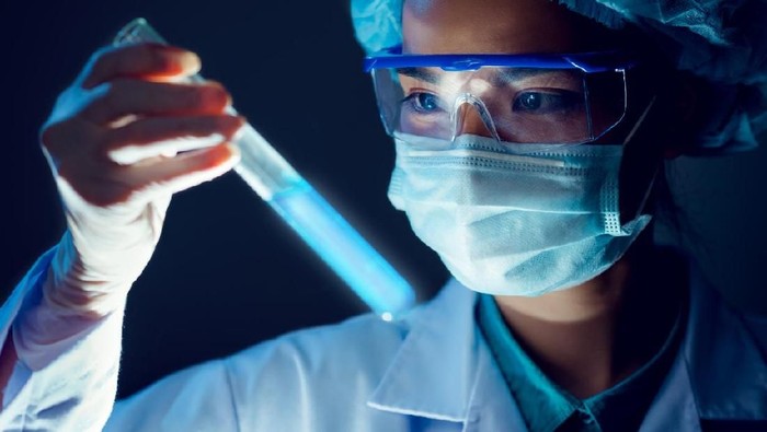 scientists lab sains Medical researcher holding test tube with blue fluorescent liquid