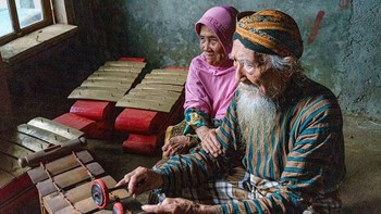 Seorang nenek menemani suaminya bermain alat musik. Foto ini diambil di Indonesia. Istimewa/Agora Images/@john_n_nadeak via Boredpanda.