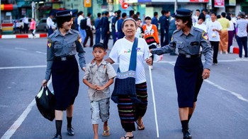 Potret dua orang polwan membantu seorang wanita tunanetra saat akan menyeberang jalan. Foto ini diambil di kota Yangon, Myanmar. Istimewa/Agora Images/@yekyawthu via Boredpanda.