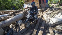 Warga mengendarai sepeda motor berusaha melewati jalan yang dipenuhi lumpur, bebatuan, serta material lainnya pascabanjir bandang di kawasan tersebut. Antara Foto/Basri Marzuki.