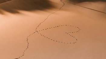 Potret jejak langkah seseorang yang membentuk lambang hati saat melintasi gurun di Maroko. Istimewa/Agora Images/@jordisark via Boredpanda.