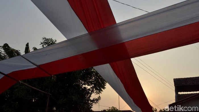 Warga kampung Tokyo Pekalongan membentangkan bendera merah putih sepajang 1 km di jalanan kampung untuk menyambut HUT ke 74 Kemerdekaan RI, (15/8/2019).