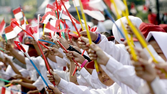 Sejumlah siswa sekolah menyambut kirab bendera berukuran besar  yang dbawa oleh gabungan elemen masyarakat, TNI dan Polri di Jalan Raya Tegar Beriman, Cibinong, Kabupaten Bogor, Jawa Barat, Kamis (15/8/2019). Kirab bendera berukuran 100 meter x 5 meter tersebut merupakan rangkaian Festival Merah Putih dalam menyambut HUT ke-74 Kemerdekaan RI. ANTARA FOTO/Yulius Satria Wijaya/hp.