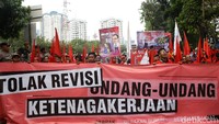 Massa membawa serta spanduk bertuliskan Tolak Revisi Undang-Undang Ketenagakerjaan.