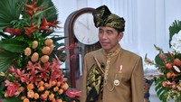 Jokowi memakai tutup kepala khas adat Sasak dengan keris di dada.