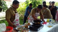 Nampaknya bapak-bapak ini tengah lomba membuat burger. Tampilannya sudah seperti chef lengkap dengan celemek bermotif bunga. Foto: Istimewa