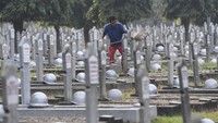 Petugas kebersihan tampak membersihkan makam di kawasan TMP Kalibata, Jakarta, Jumat (16/8/2019).
