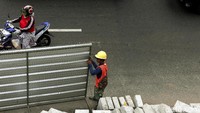 Sejumlah pekerja tengah menyelesaikan pembuatan proyek revitalisasi trotoar.