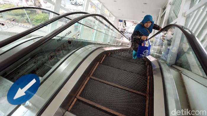 Sejumlah petugas melakukan perawatan dan pemeliharaan eskalator JPO di halte TransJ Salemba Carolus, Jakarta Pusat.