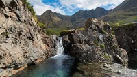 Fairy Pools berada di balik Hutan Glenbrittle. Barisan air terjun di tempat ini jatuh ke kolam-kolam alam dengan warna toska dan biru yang indah. (iStock)