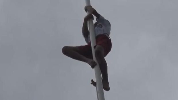 Siswa SD di Ambon membetulkan pengait Bendera Merah Putih, Sabtu (17/8/2019) 