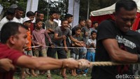 Sejumlah penonton memberikan dukungan kepada para peserta lomba tarik tambang.
